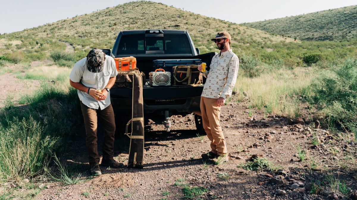 Duck Camp F26 — two men in printed performance shirts at a truck tailgate